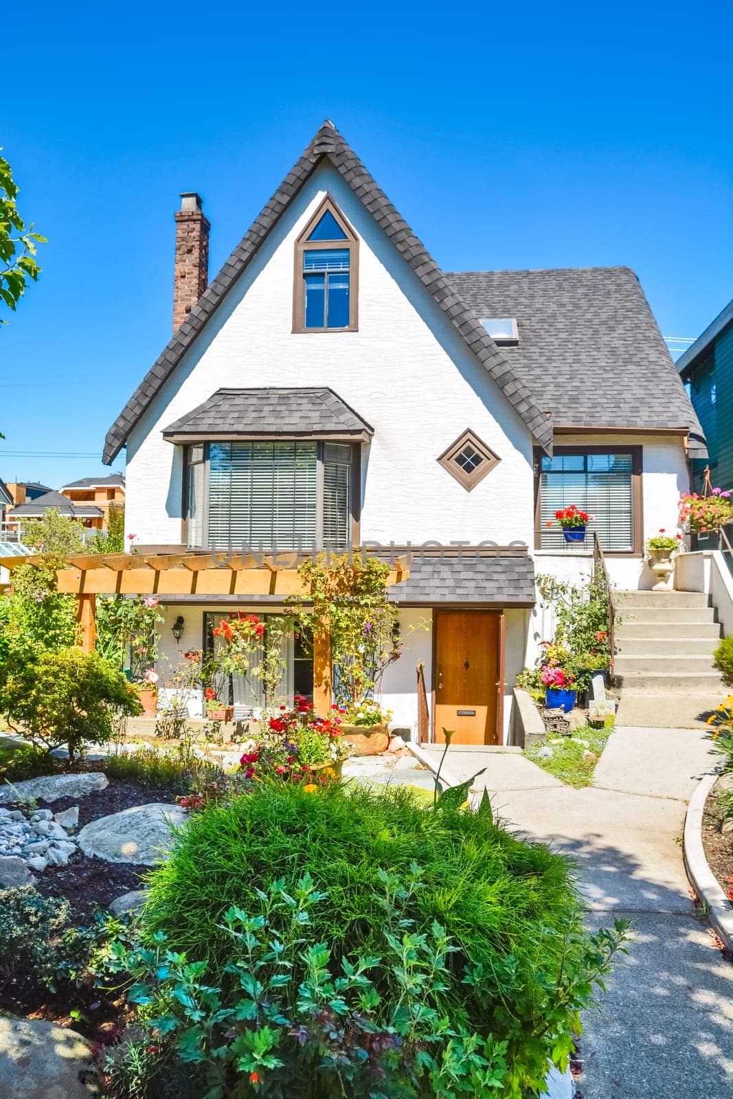 Old style family house with landscaped front yard and concrete pathway to the entrance
