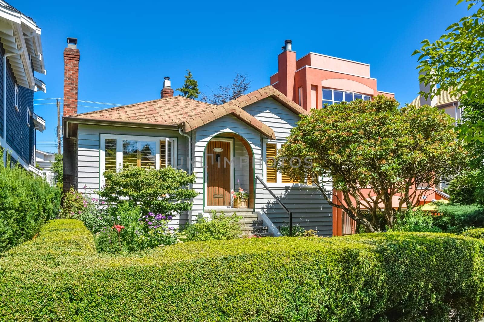 Residential house with green hedge on front yard.