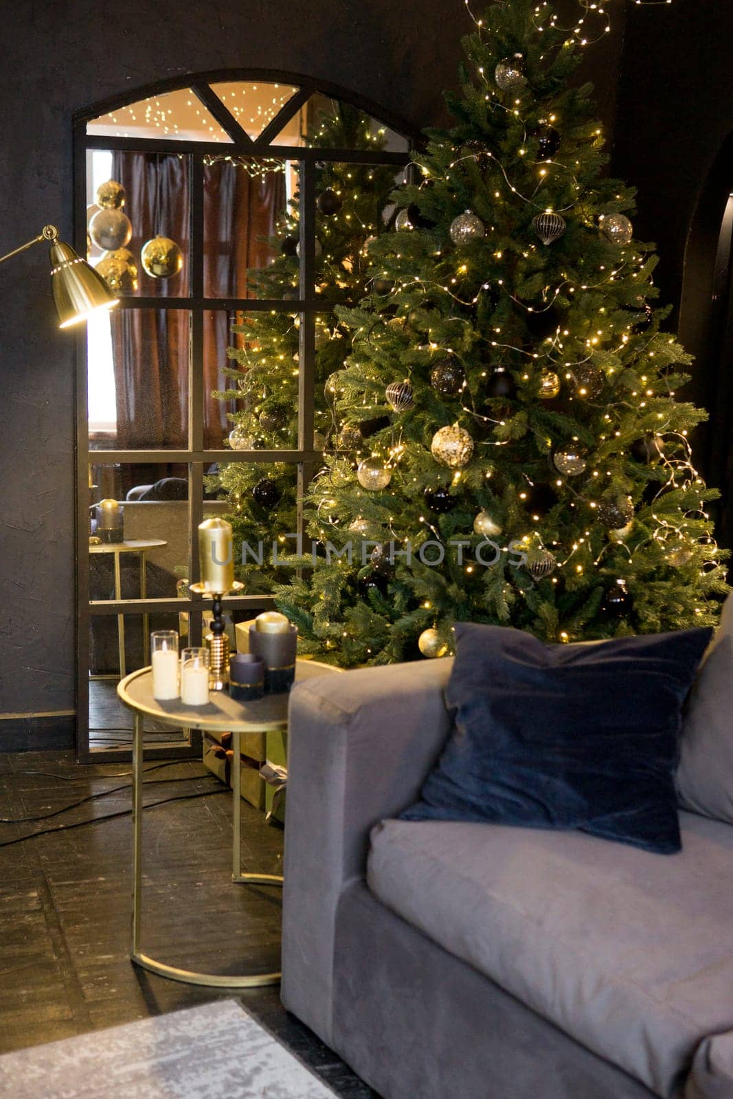 Christmas interior with a beautiful Christmas tree, sofa, light bulbs and dark background