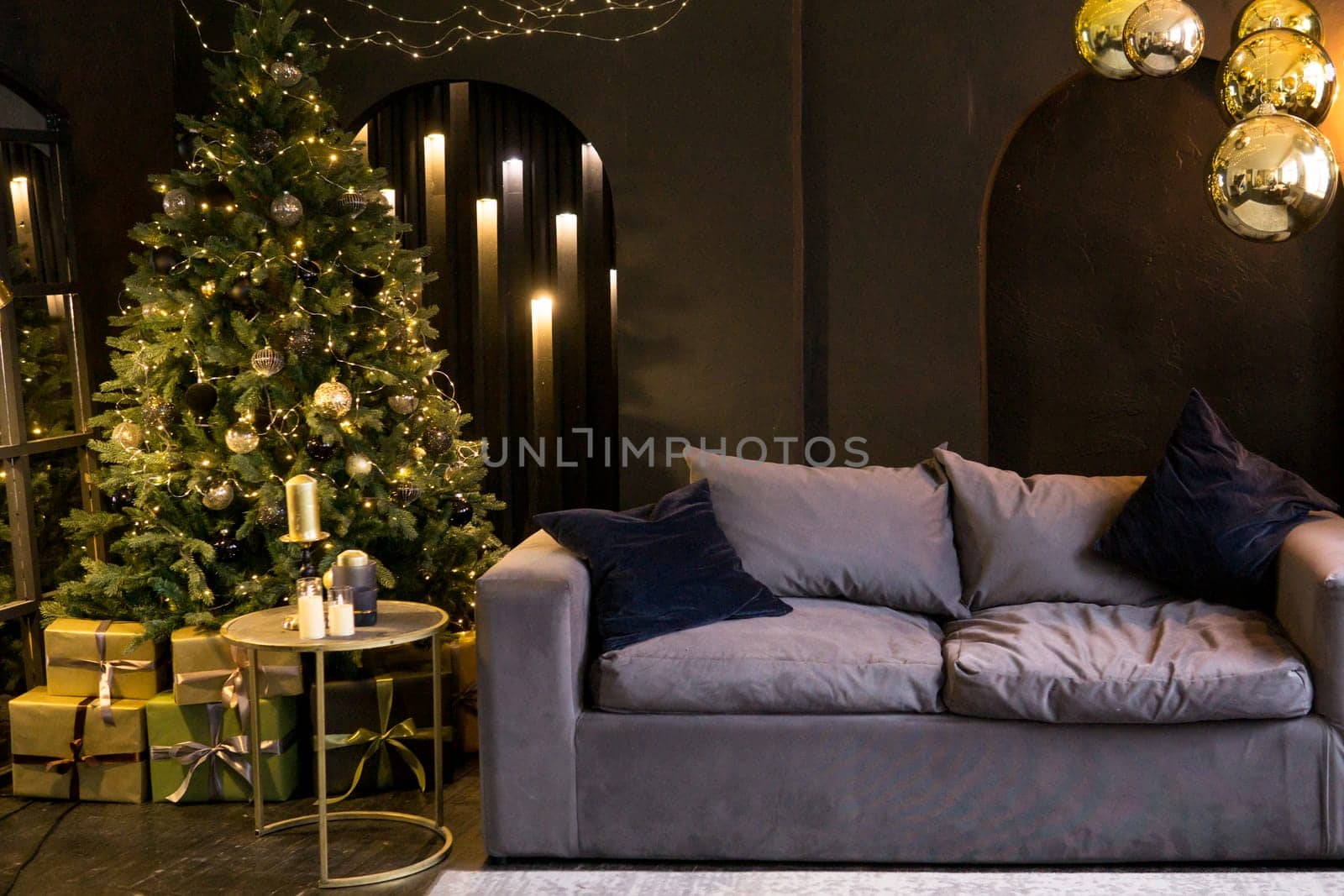 Christmas interior with a beautiful Christmas tree, sofa, light bulbs and dark background