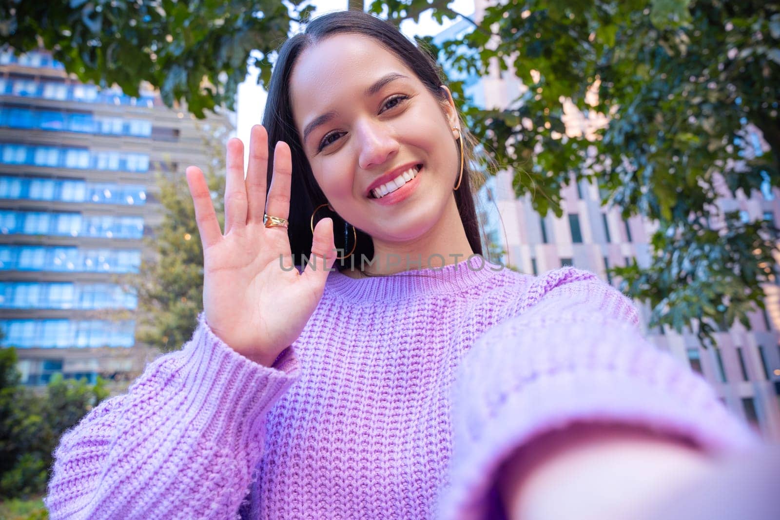 Happy young latin taking a selfie with smartphone.
