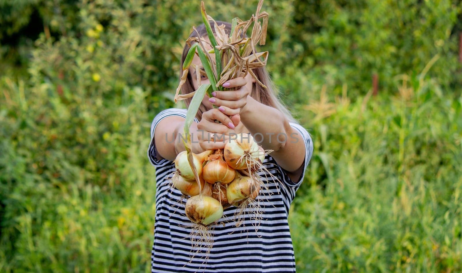 woman farmer holds onions in her hands. harvest