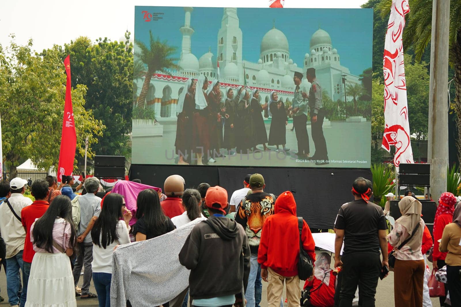 17 August 2024, Jakarta, Indonesia. The atmosphere near the Jakarta Palace during Indonesia's Independence Day is electric, filled with patriotic fervor and national pride. Crowds of people, dressed in red and white, gather to witness the flag-raising ceremony and participate in various festivities.