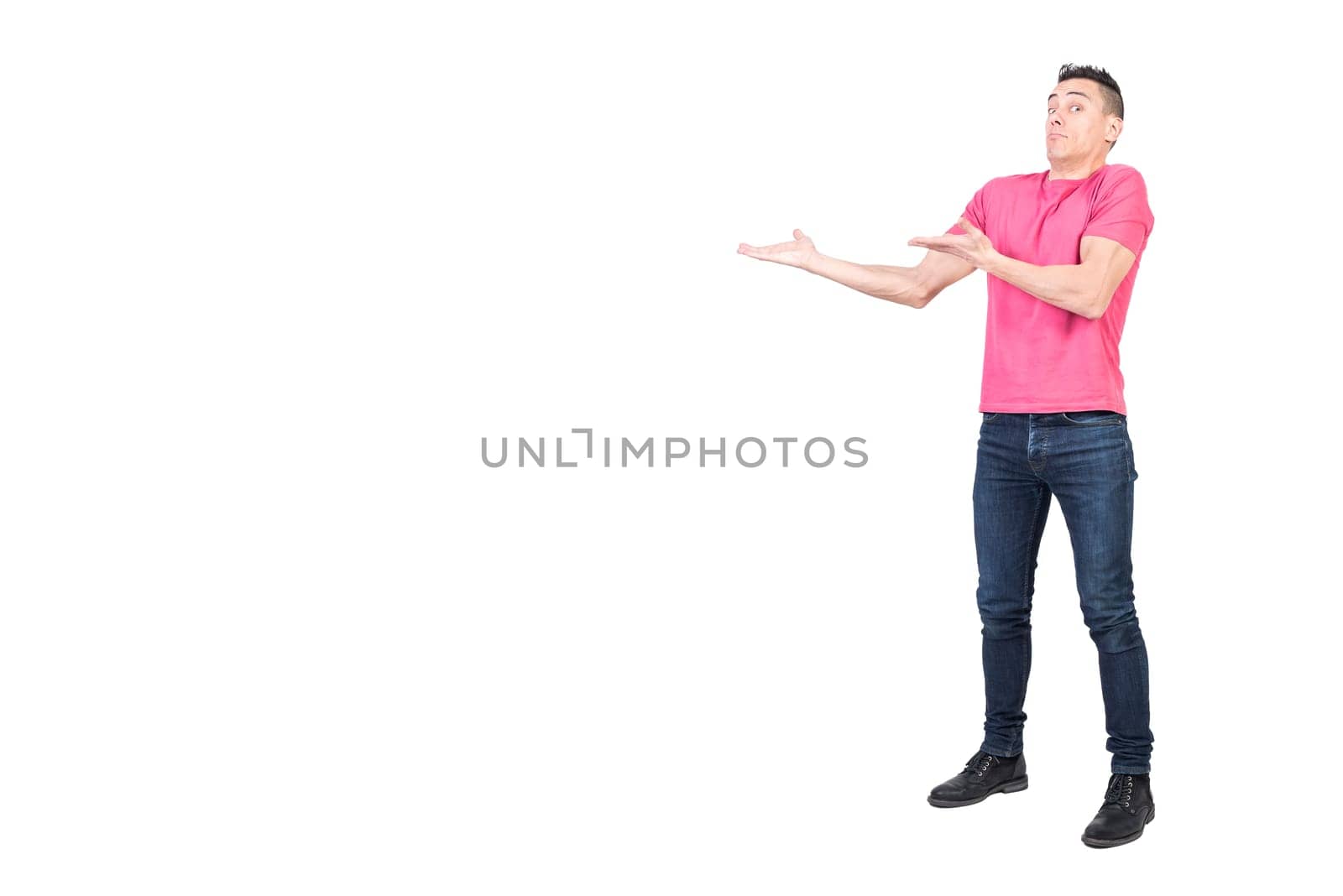 Full body of confused male model in casual outfit pointing aside and looking at camera with amazed face isolated on white background