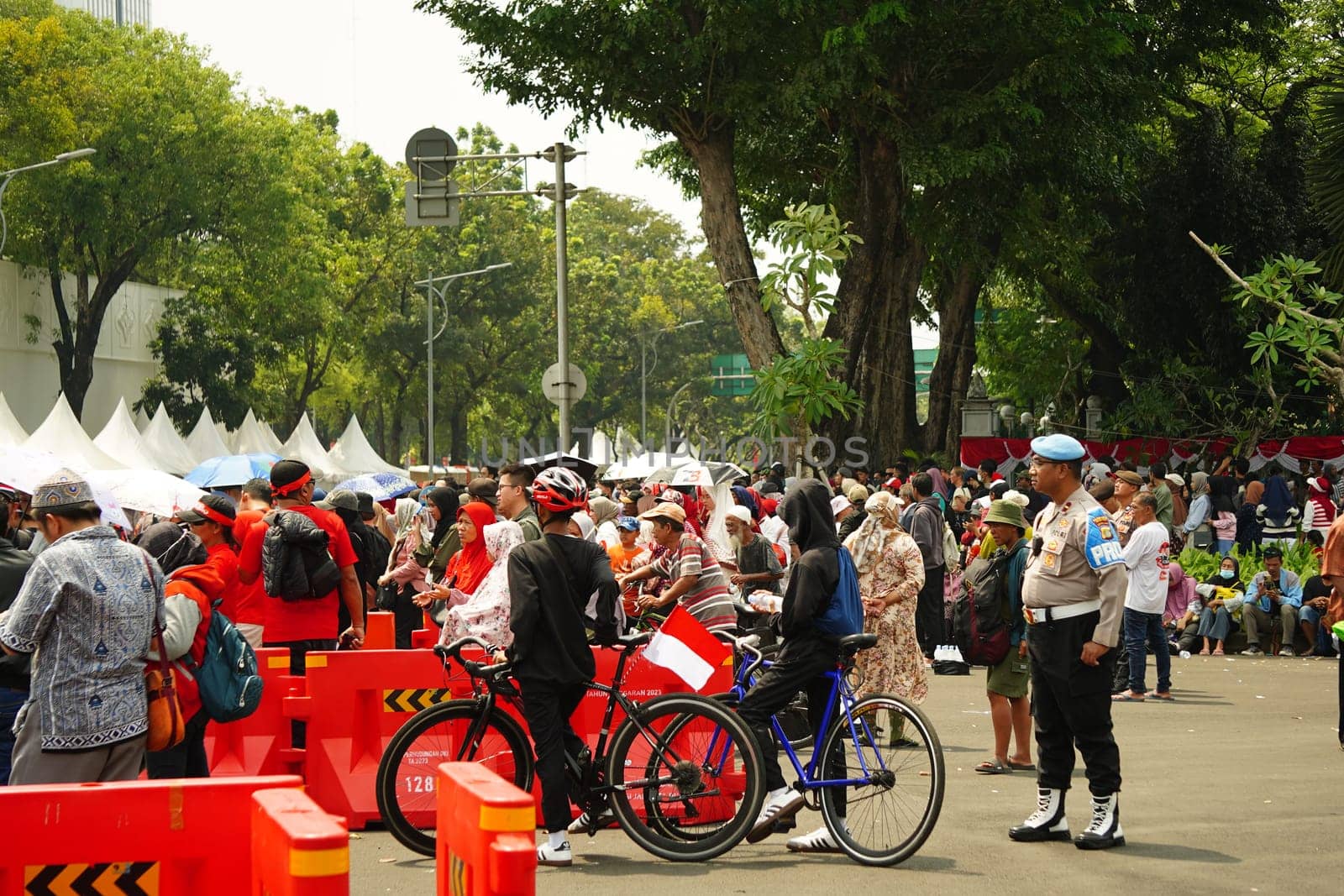 17 August 2024, Jakarta, Indonesia. The atmosphere near the Jakarta Palace during Indonesia's Independence Day is electric, filled with patriotic fervor and national pride. Crowds of people, dressed in red and white, gather to witness the flag-raising ceremony and participate in various festivities.