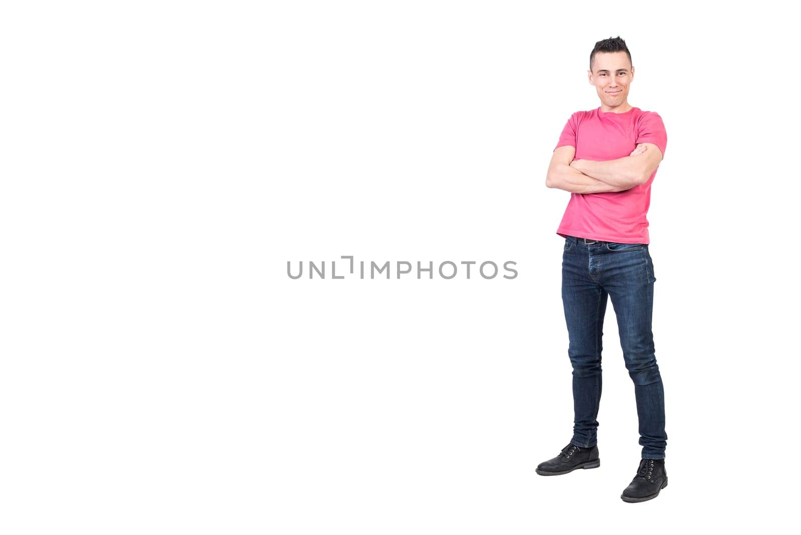 Full body of positive young male model in casual outfit looking at camera with crossed arms isolated on white background