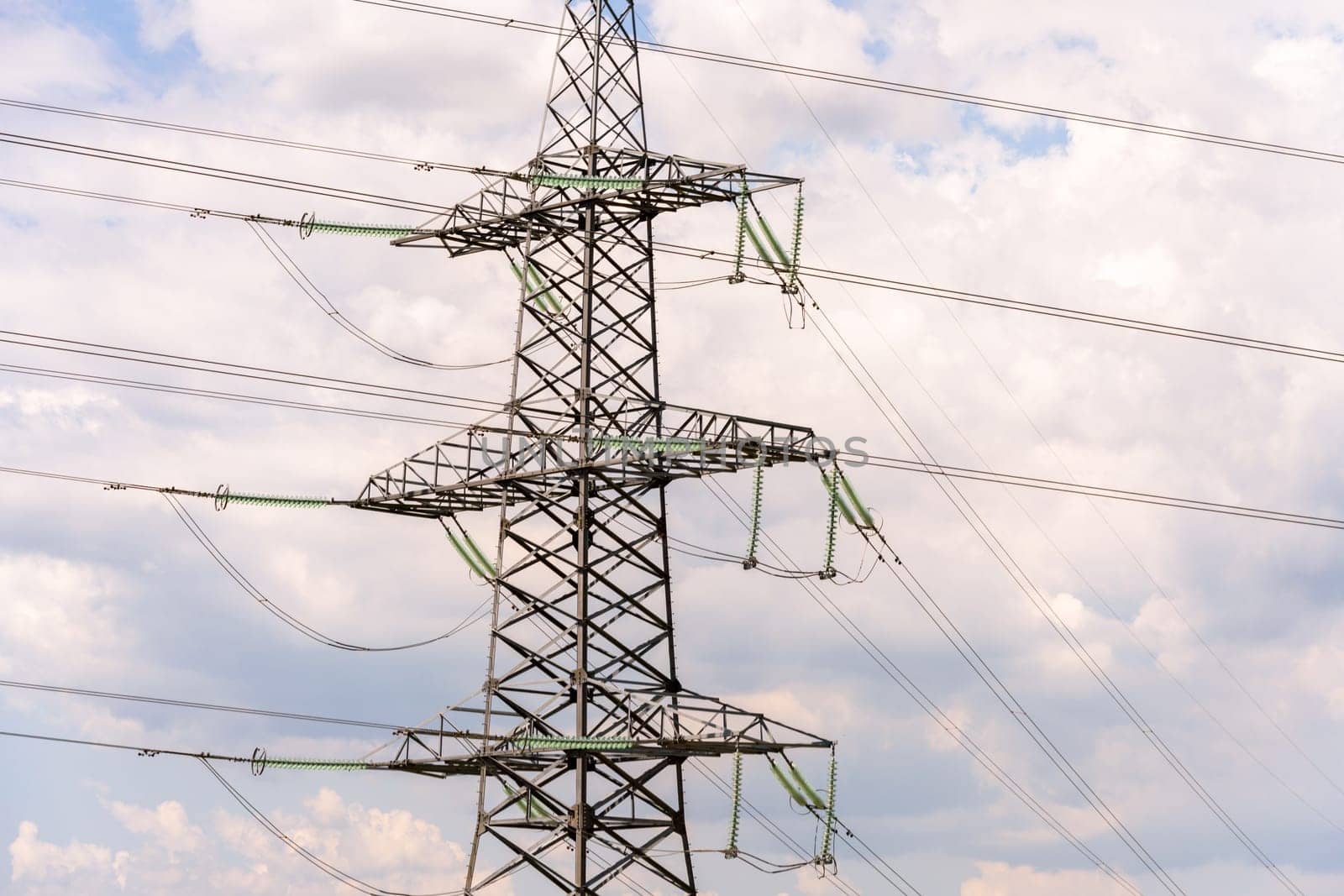 High voltage towers with sky background. Power line support with wires for electricity transmission. High voltage grid tower with wire cable at distribution station. Energy industry, energy saving.
