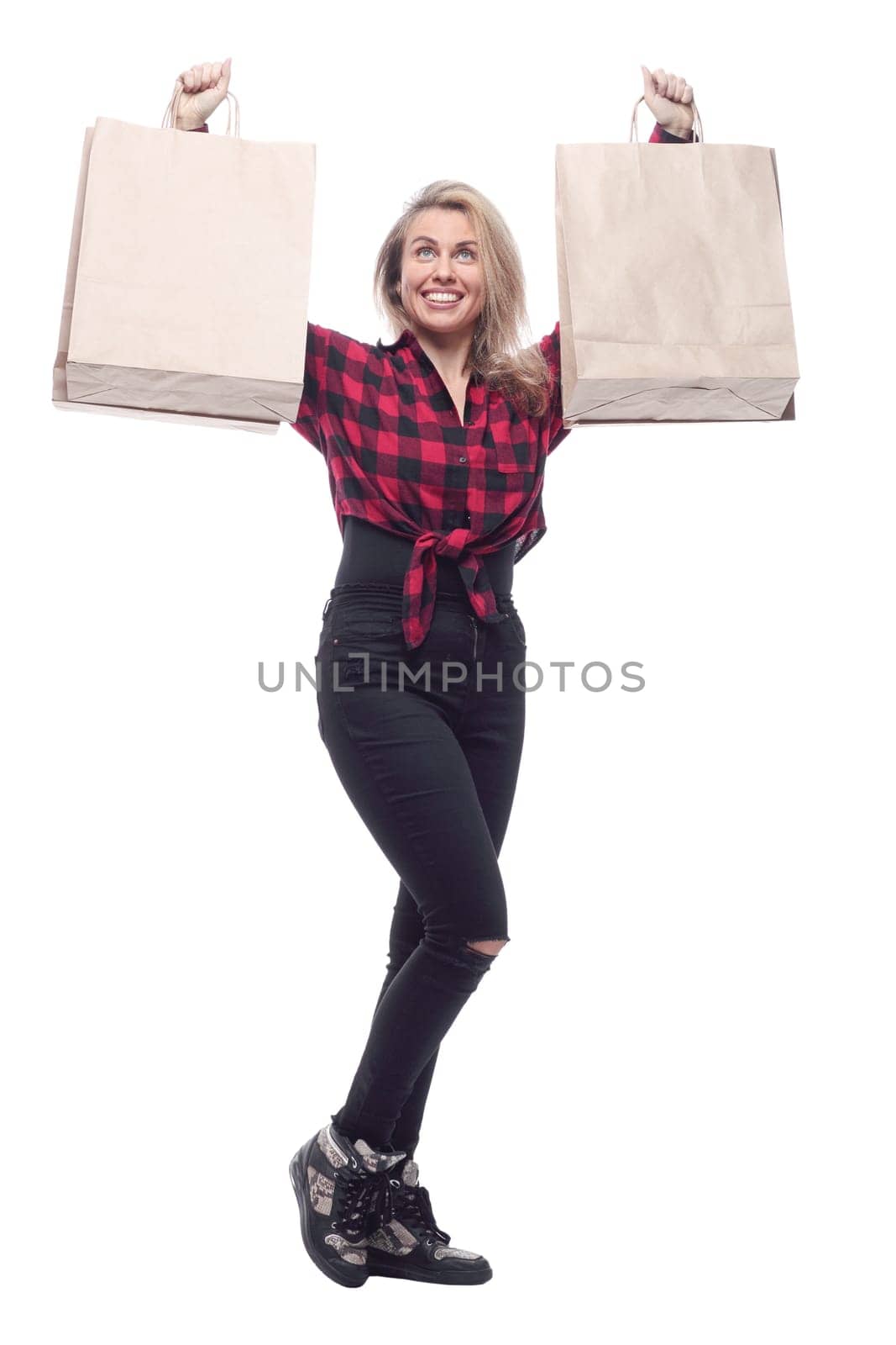 casual young woman with shopping bags striding forward . isolated on a white background.