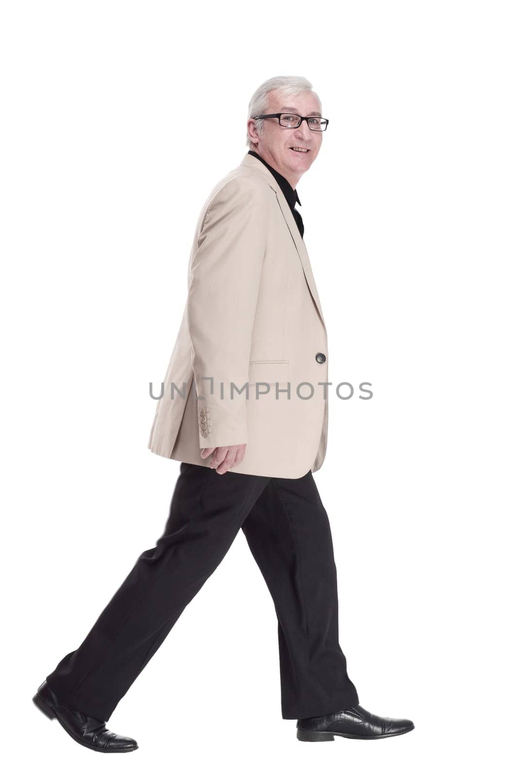 intelligent mature man in a white jacket walking forward . isolated on a white background.