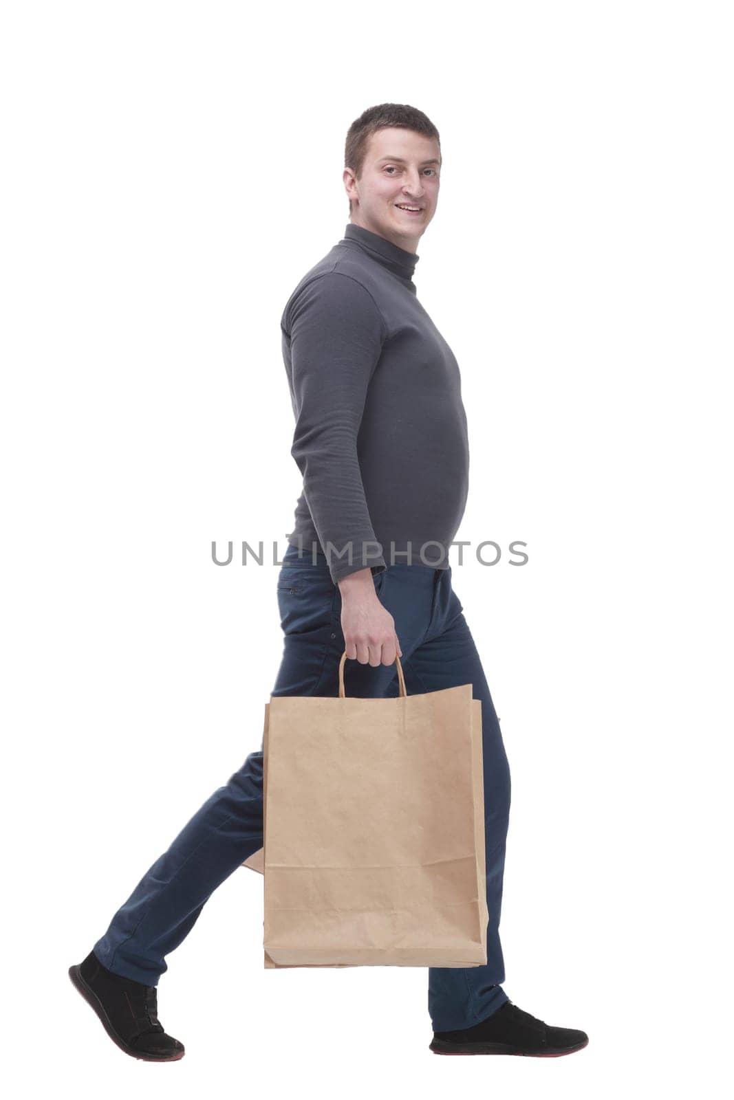 in full growth. casual young man with shopping bags. isolated on a white background.