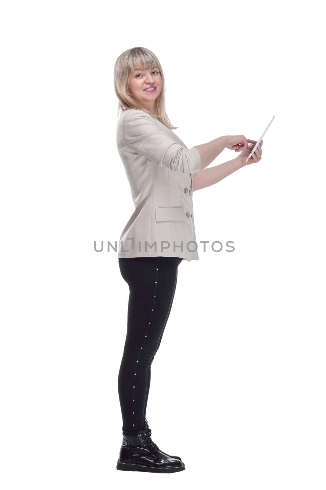 side view. attractive blonde woman using her digital tablet . isolated on a white background.