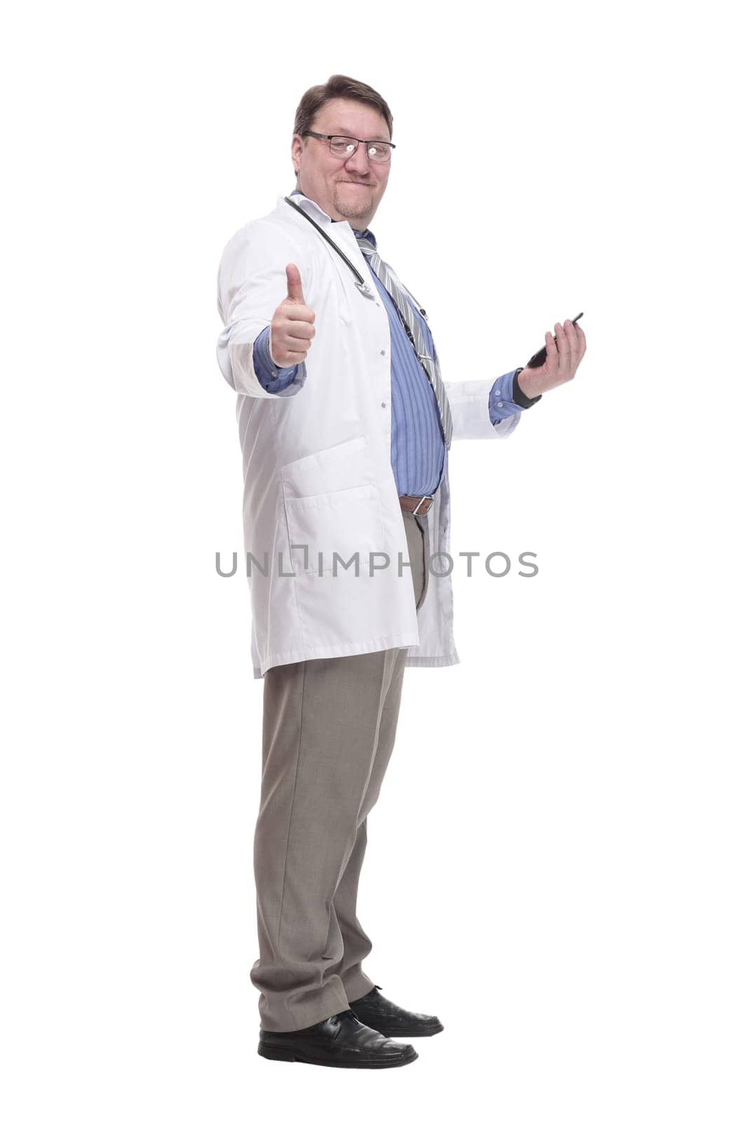 in full growth. qualified doctor with a smartphone.isolated on a white background.