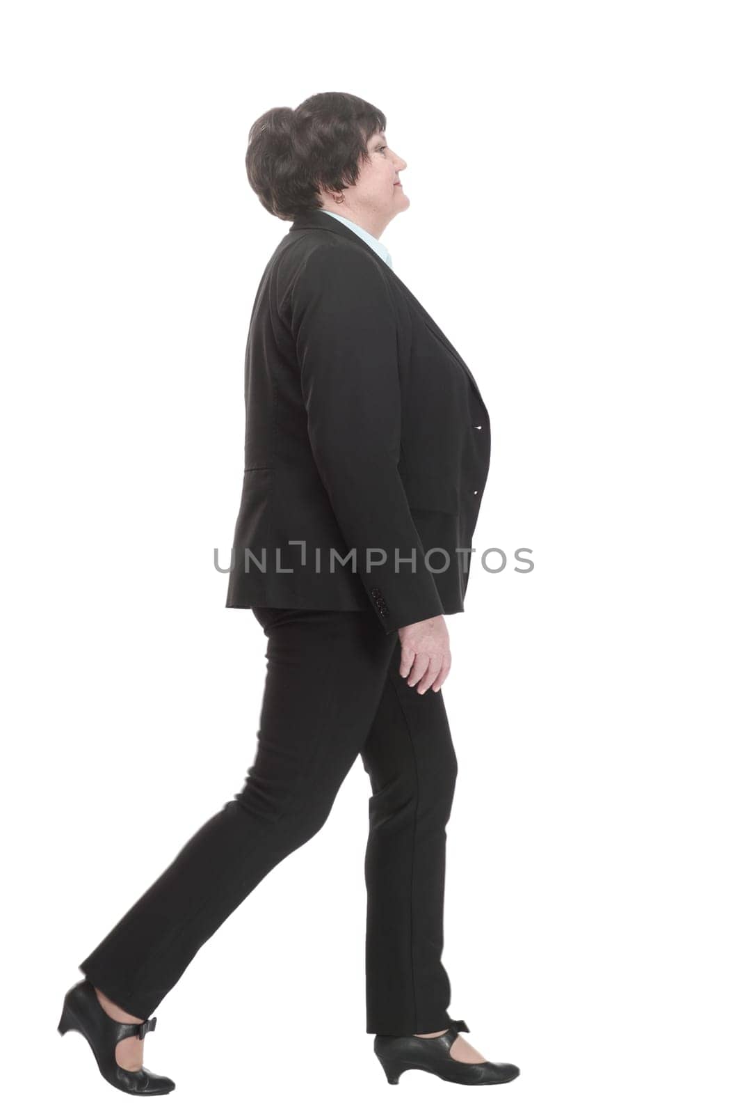 Mature business woman in a pantsuit striding forward. isolated on a white background.