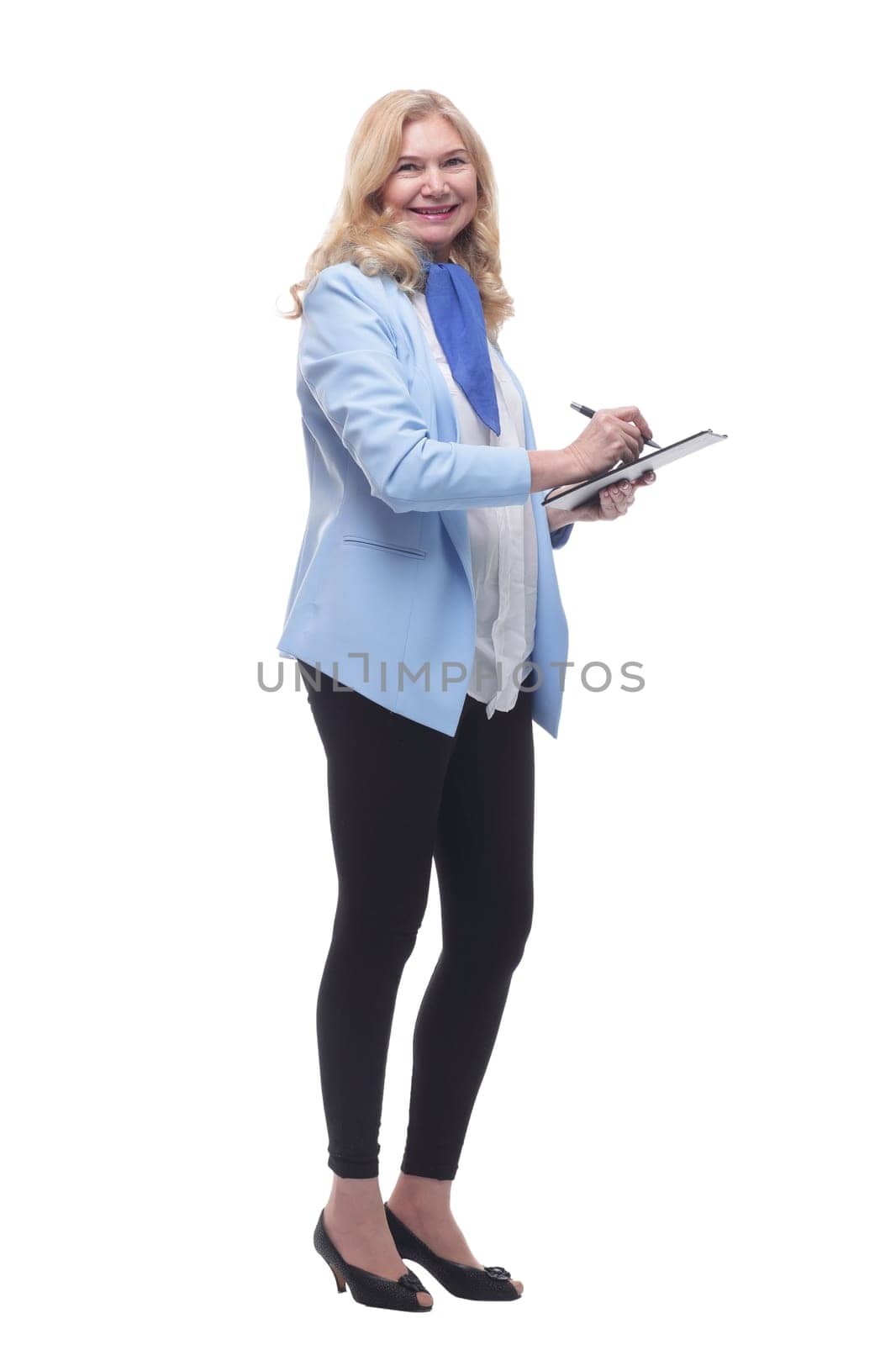 in full growth. smiling woman making a note in the clipboard . isolated on a white background.