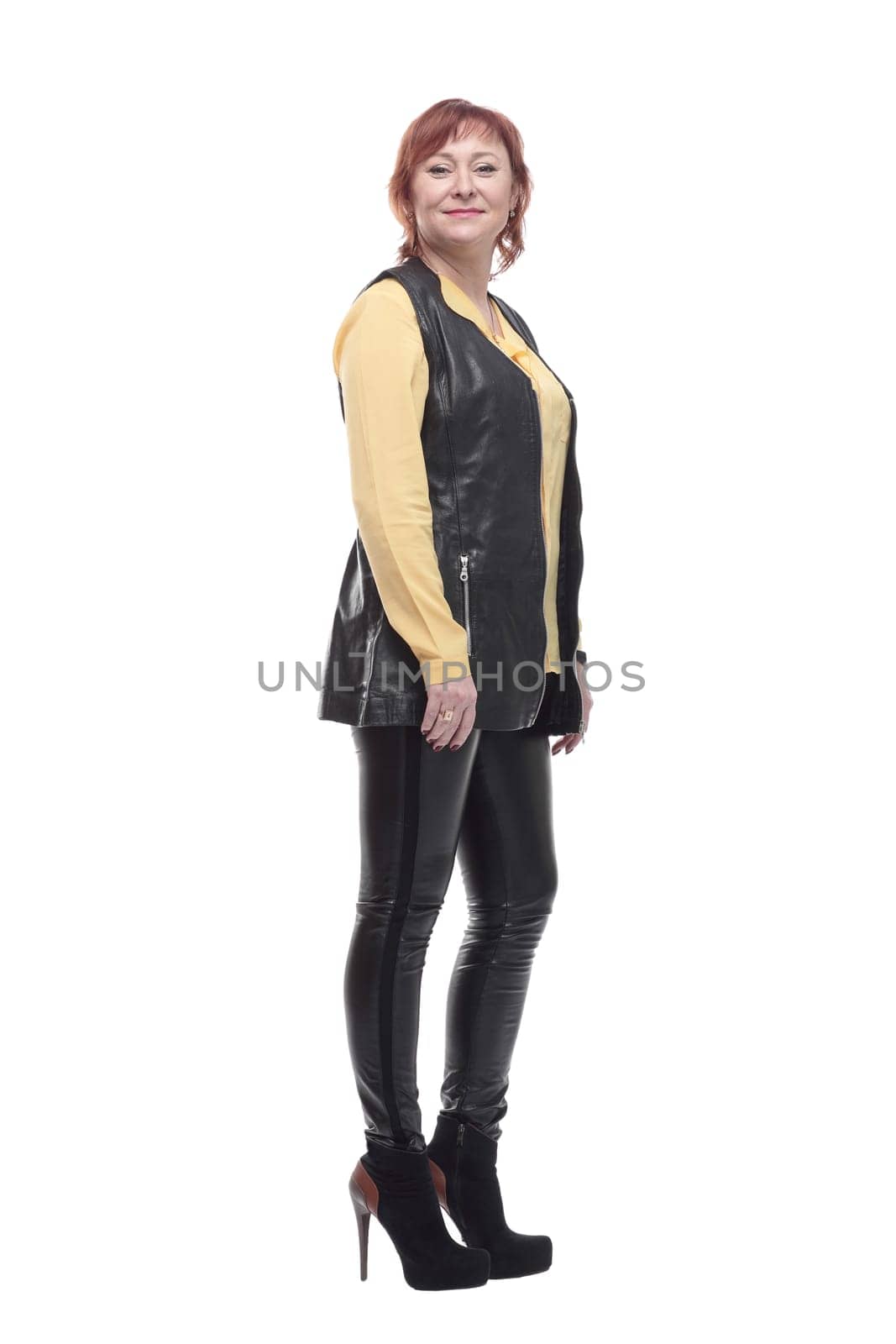attractive mature woman in leather trousers and vest. isolated on a white background.
