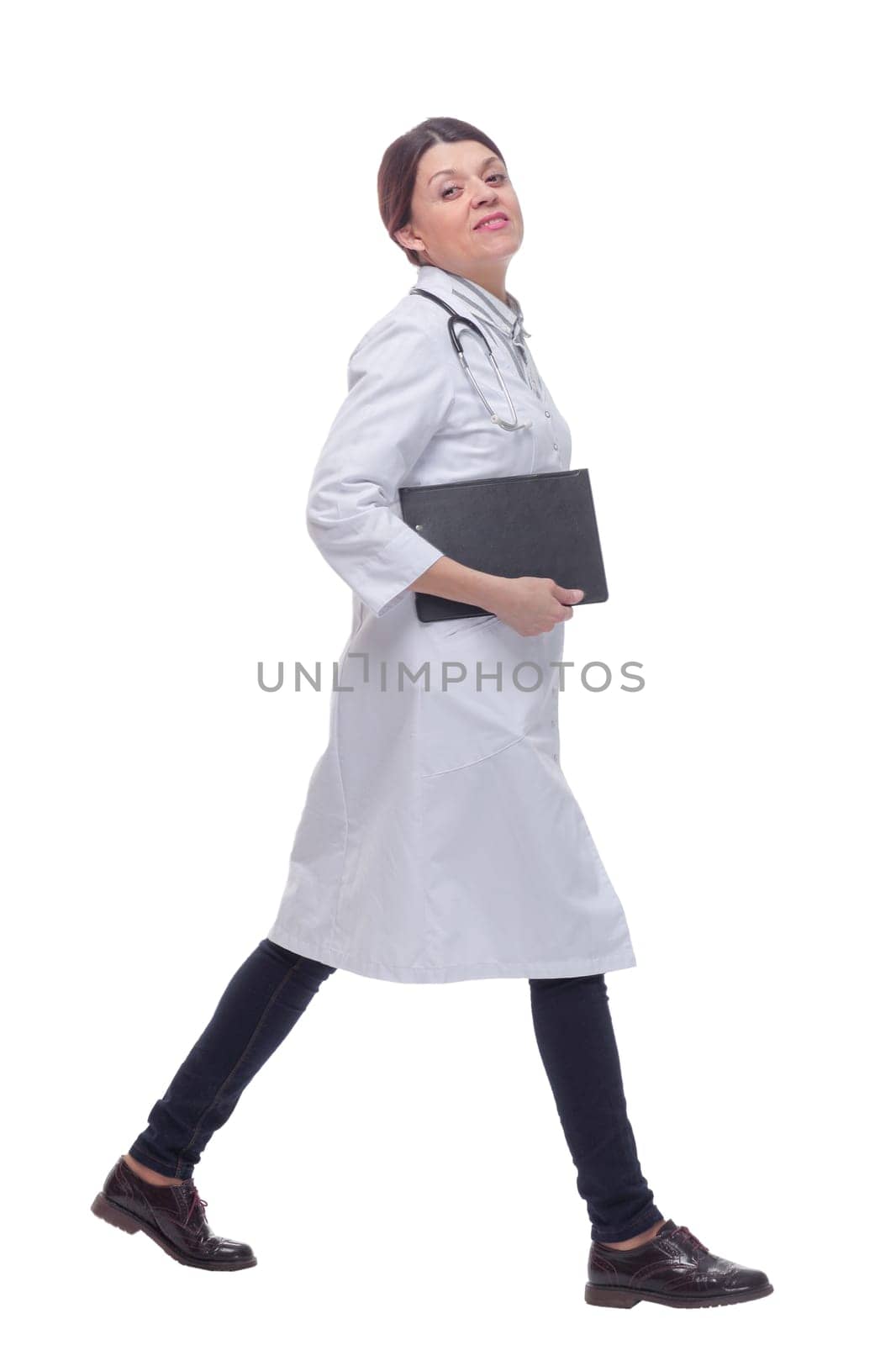 Portrait of female doctor walking towards the camera smiling isolated over a white background