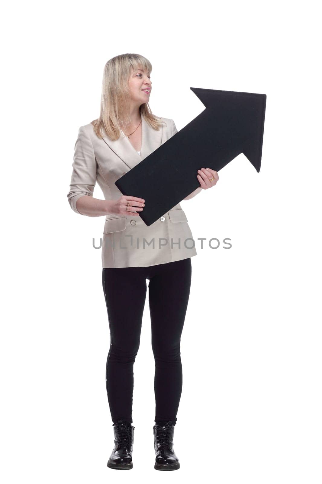 in full growth. an attractive woman in a white jacket pointing in the right direction. isolated on a white background.