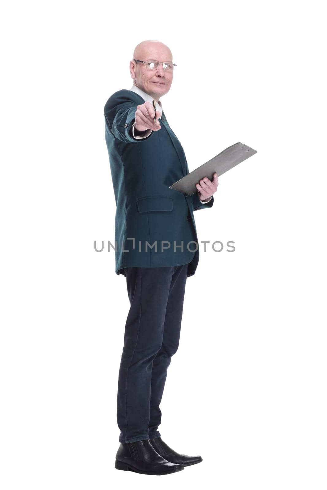 side view. serious business man writing something in the clipboard. isolated on a white background.