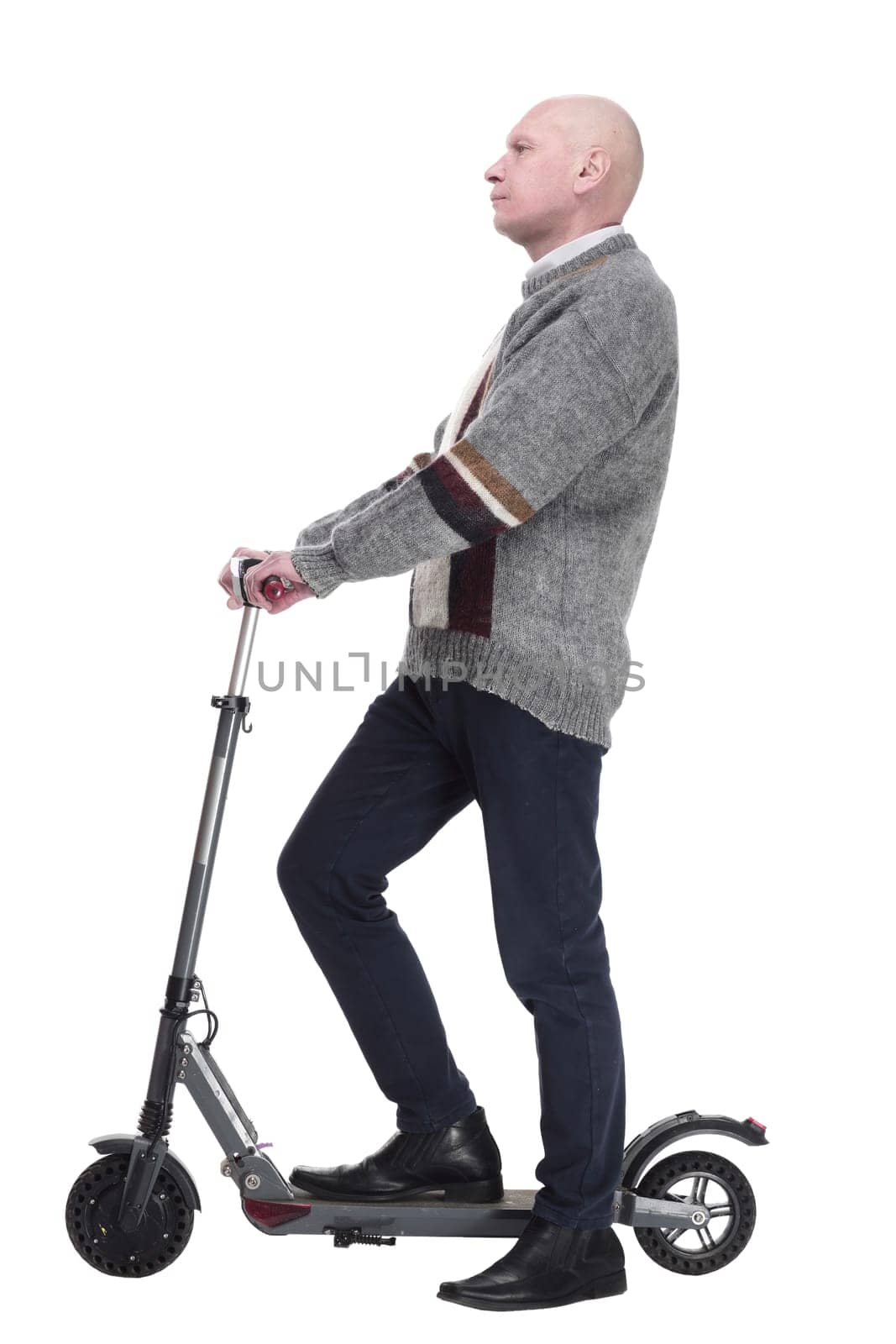 side view. mature man with electric scooter looking at you. isolated on a white background.