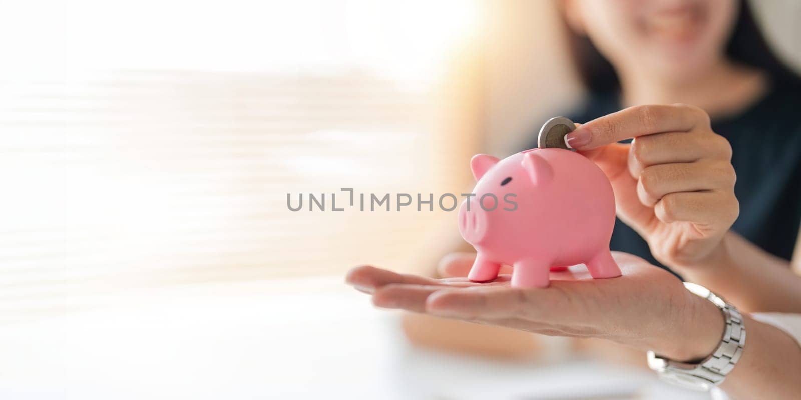 Family savings. Happy couple asian putting coin in piggybank while sitting together on desk at home, loving spouse planning budget and saving money for future.