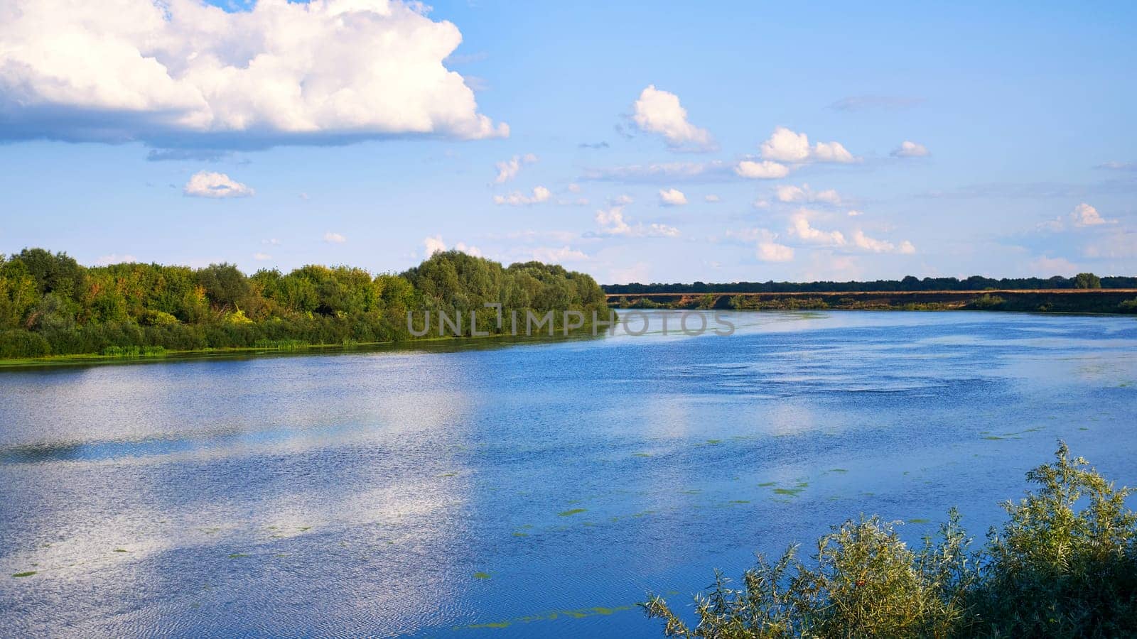 Landscape with a river and blue sky with white clouds