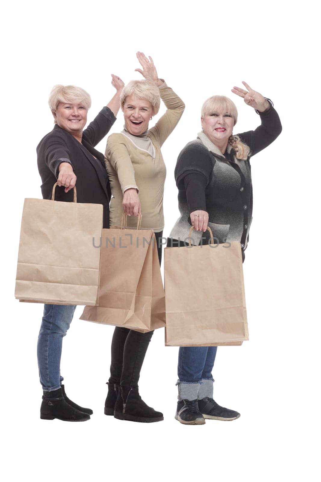 in full growth. three happy women with shopping bags. isolated on a white background.