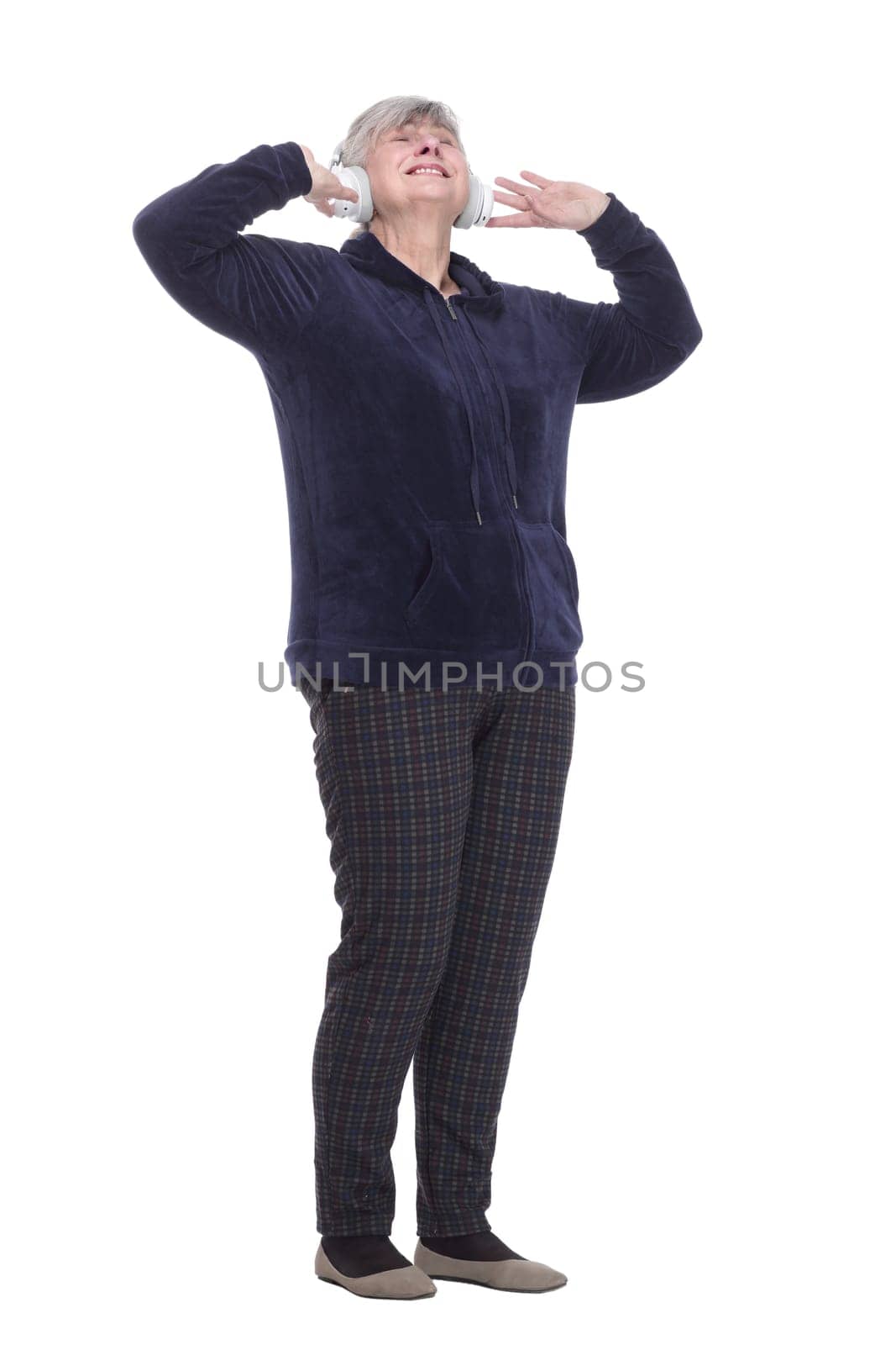 in full growth. contented old woman with headphones . isolated on a white background.