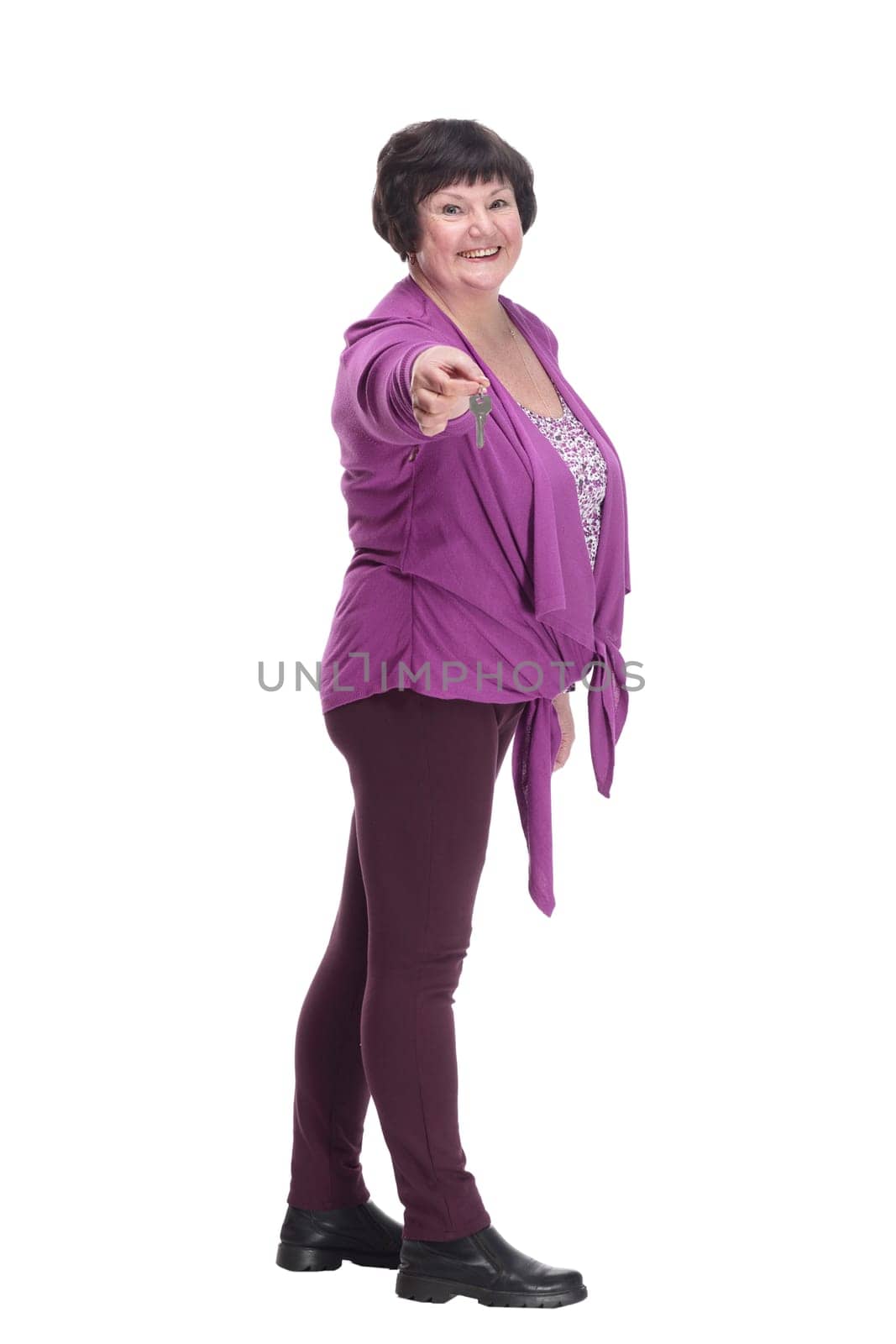 in full growth.happy senior woman with keys in hand. isolated on a white background.