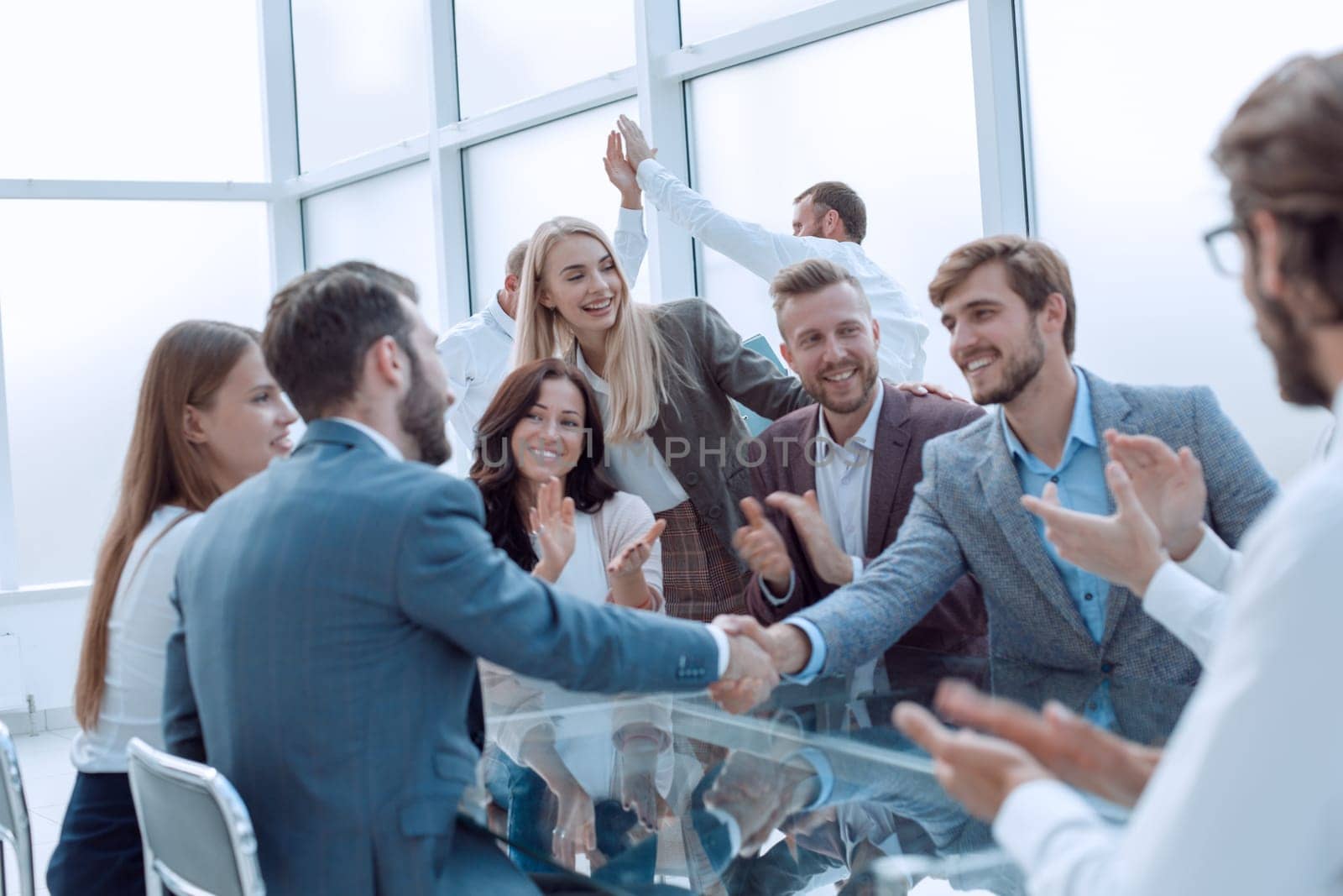 business people shaking hands sitting at the office Desk by asdf