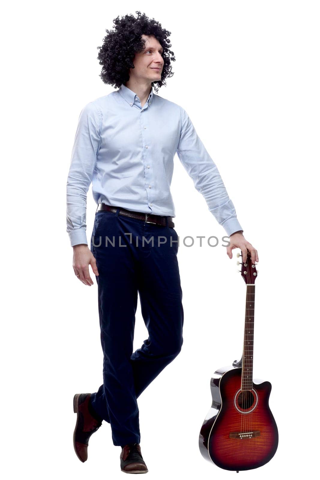 in full growth. a cheerful curly-haired man with a guitar . isolated on a white background