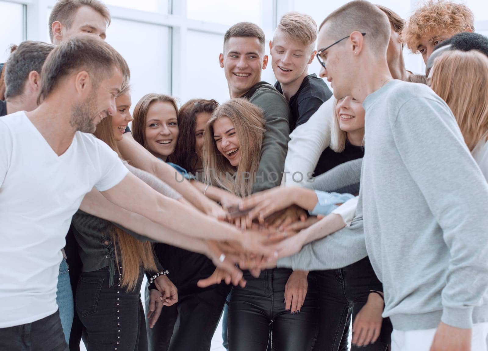 close up. a group of young people making a tower out of their hands.