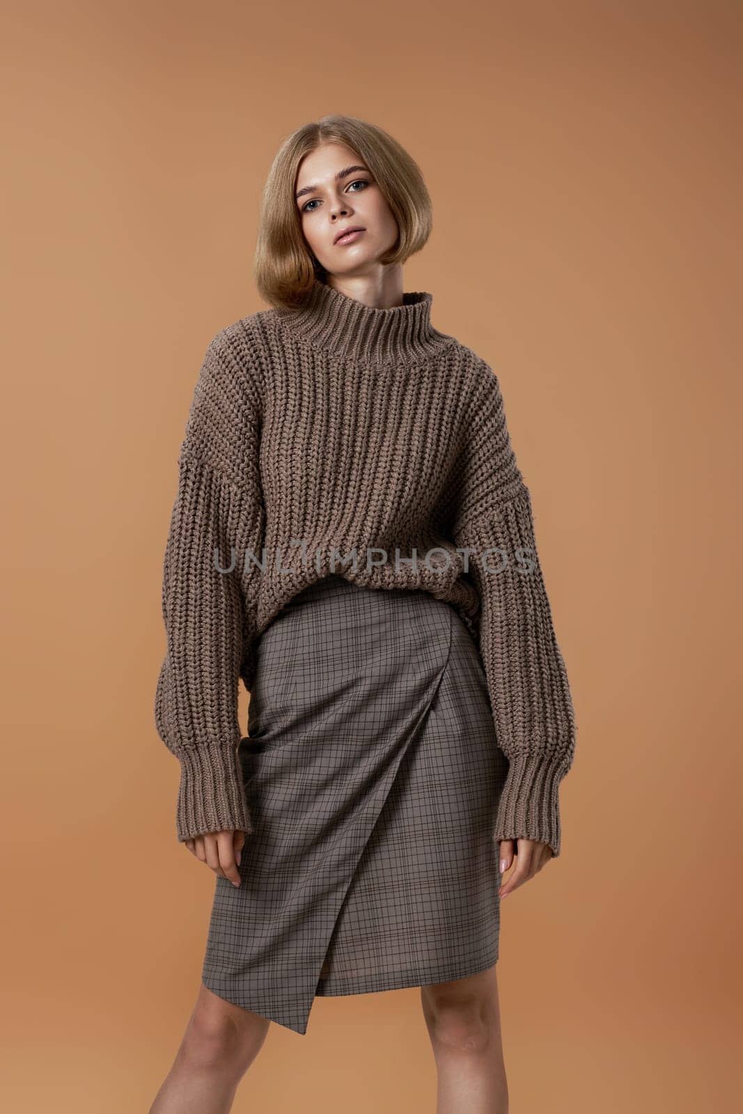 beautiful blonde woman in brown knitted sweater by erstudio