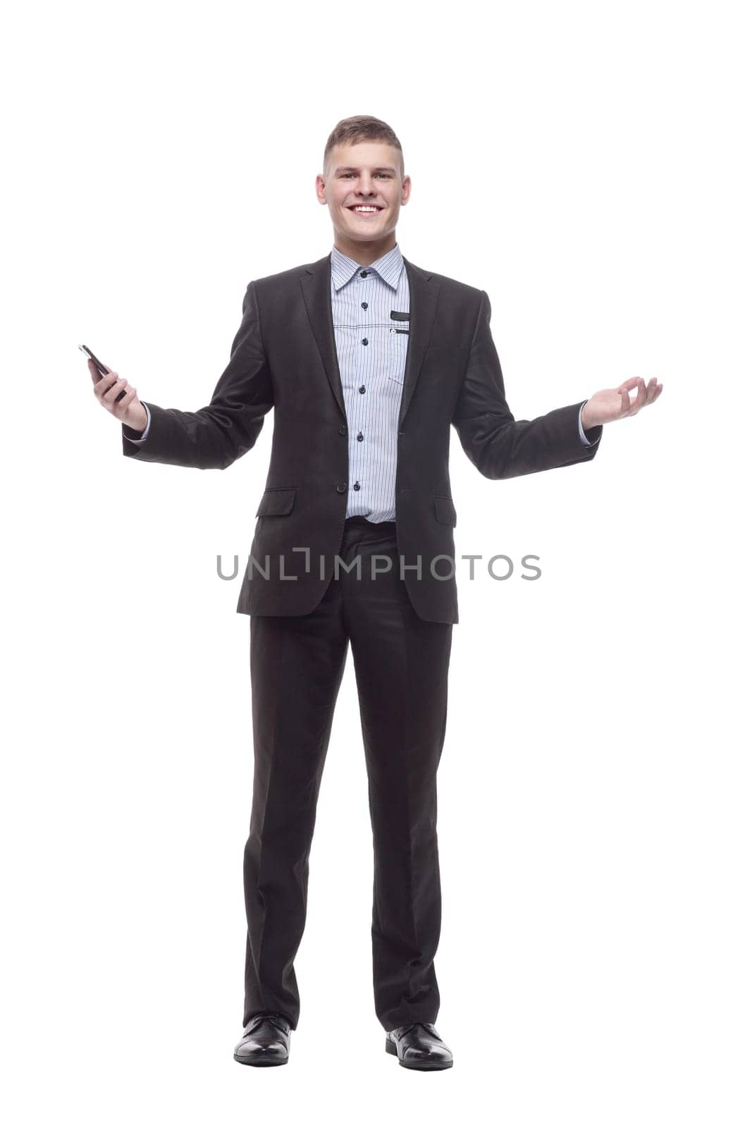 in full growth. happy young businessman with a new smartphone . isolated on a white background.
