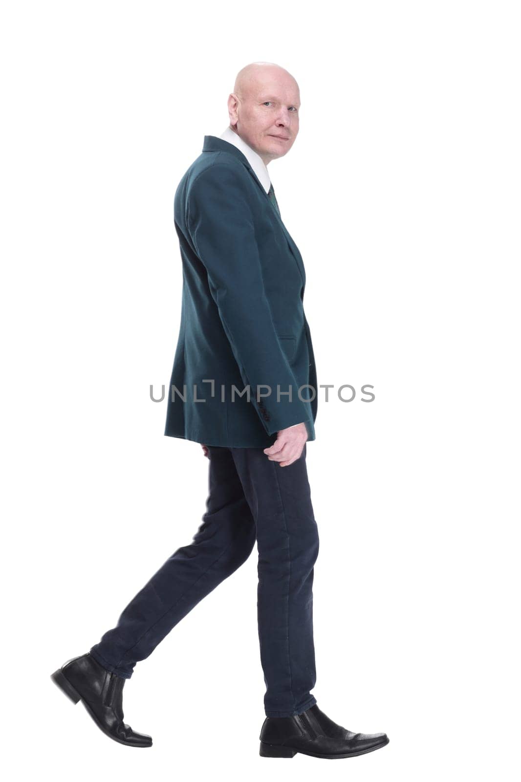 in full growth. Mature business man striding forward. isolated on a white background.