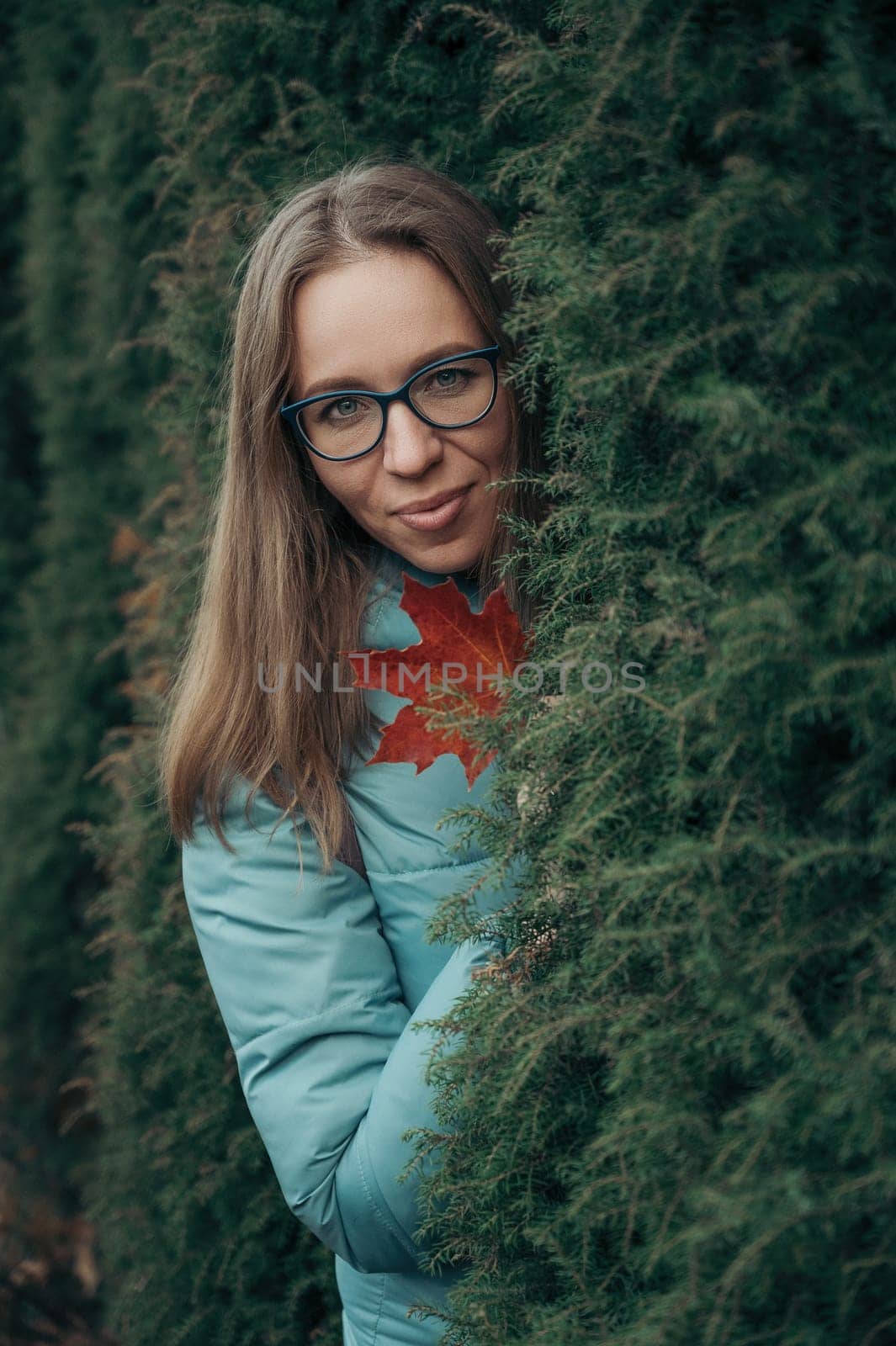 Autumn portrait of beautiful woman on thuja nature background