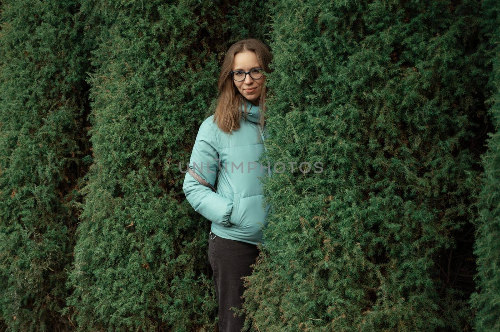 Autumn portrait of beautiful woman on thuja nature background