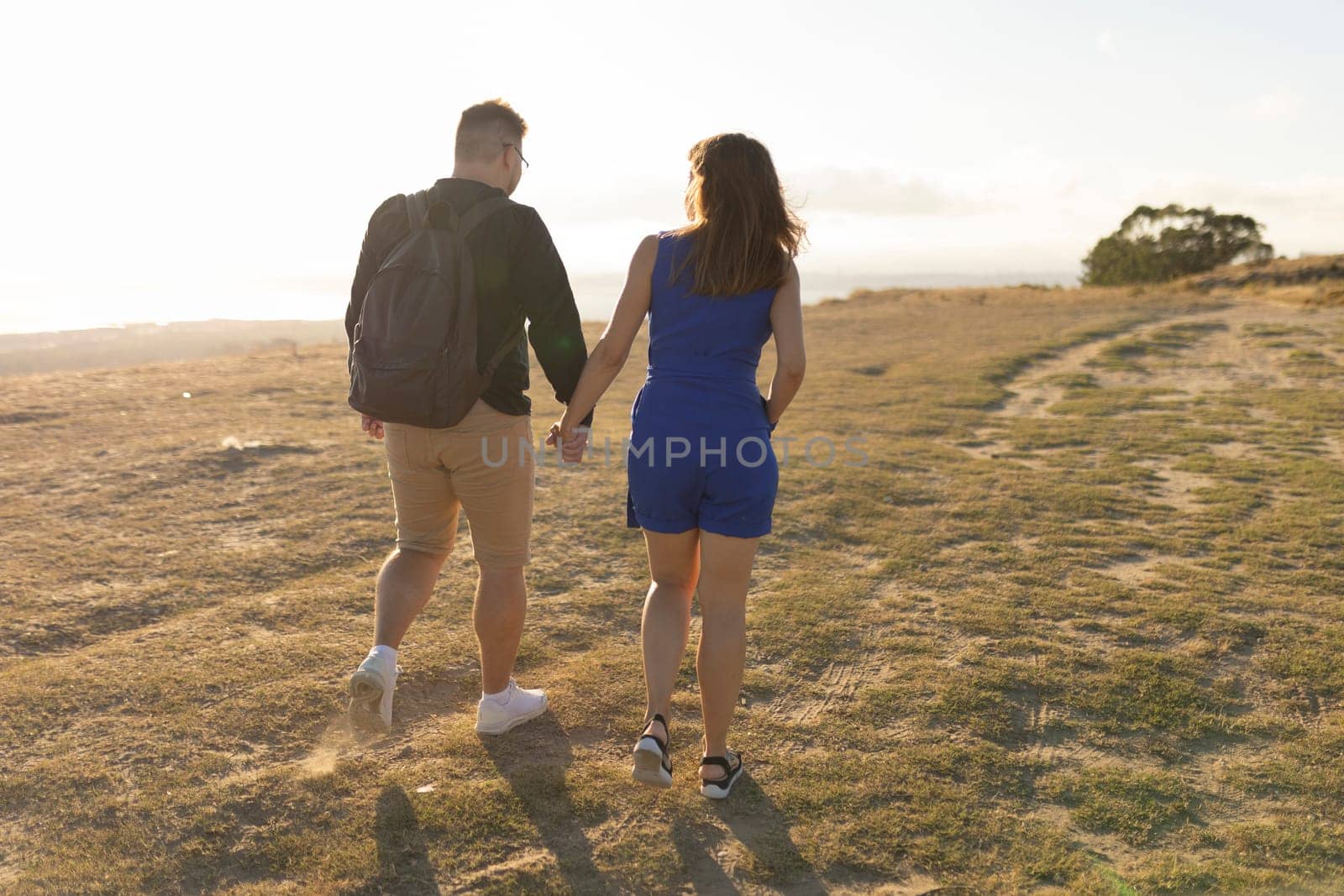 Young couple is enjoying a romantic walk in nature on a beautiful summer evening