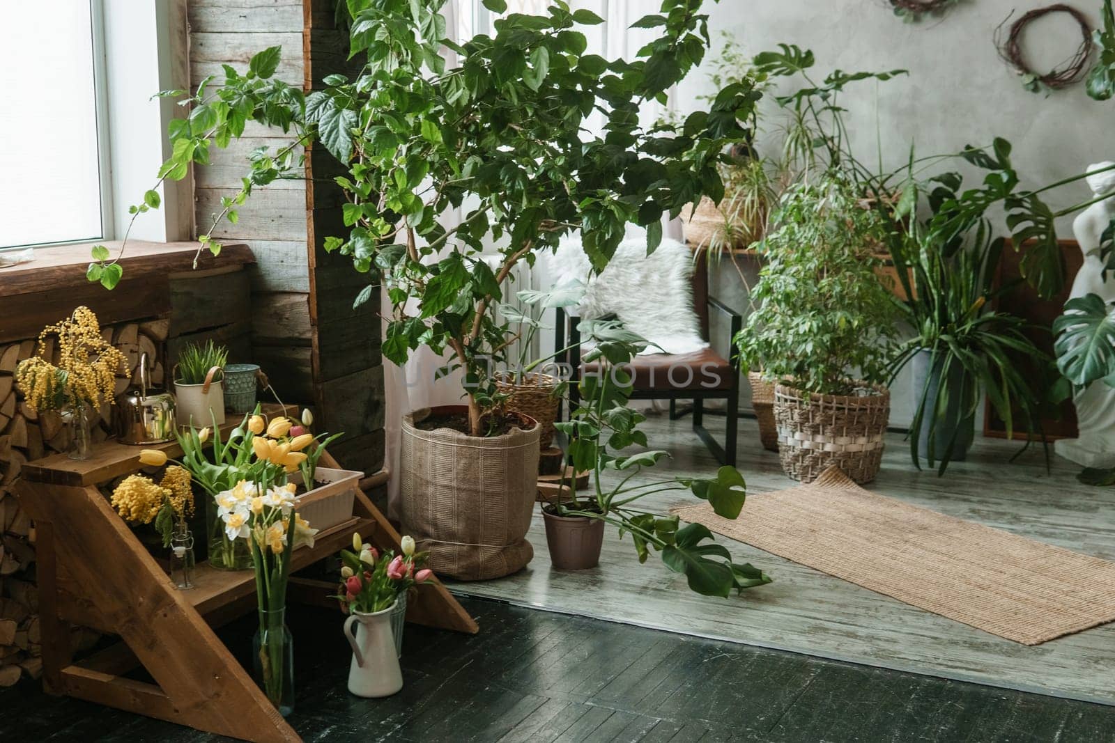 A fragment of the interior with a variety of indoor plants and plaster sculptures. Urban jungle concept. Biophilia design.