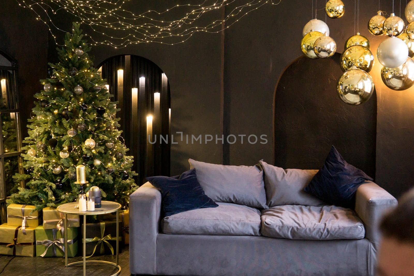 Christmas interior with a beautiful Christmas tree, sofa, light bulbs and dark background