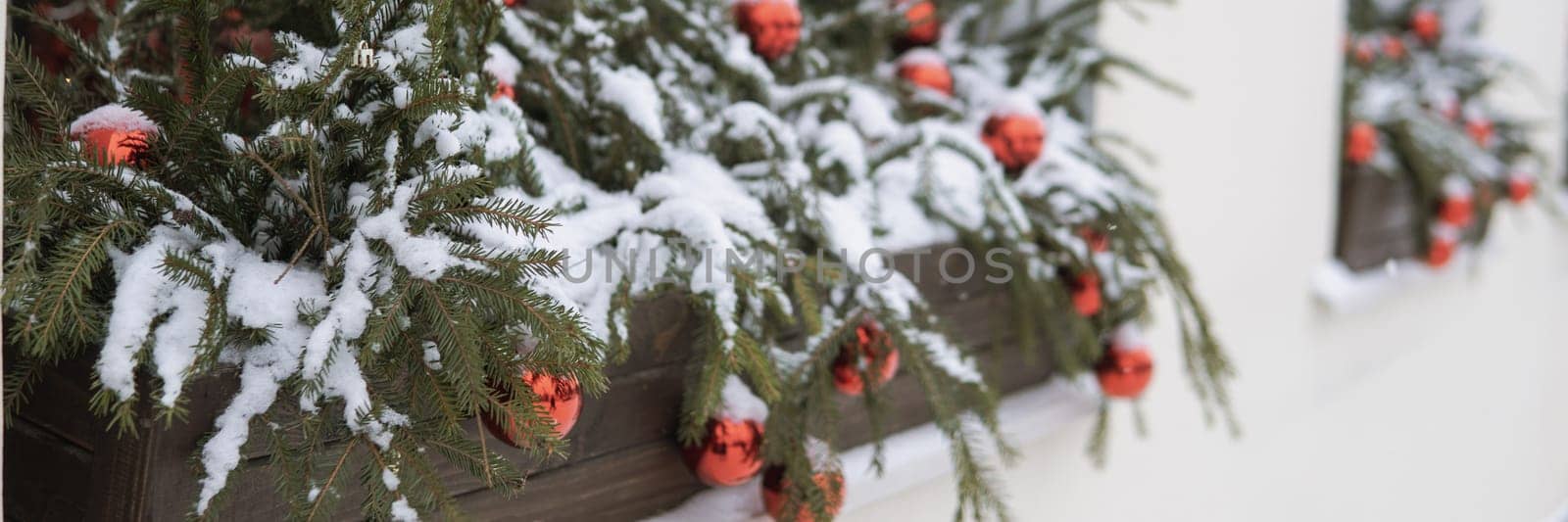 Christmas trees decorated with red balloons in front of the cafe entrance. Street New Year decorations.
