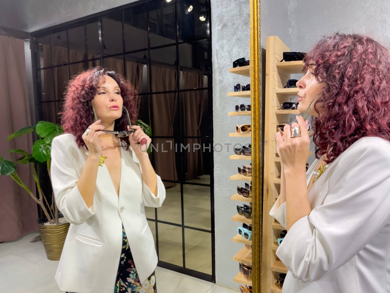 Shopping woman, women's fashion clothes in a store, boutique. Woman choosing clothes in a store.