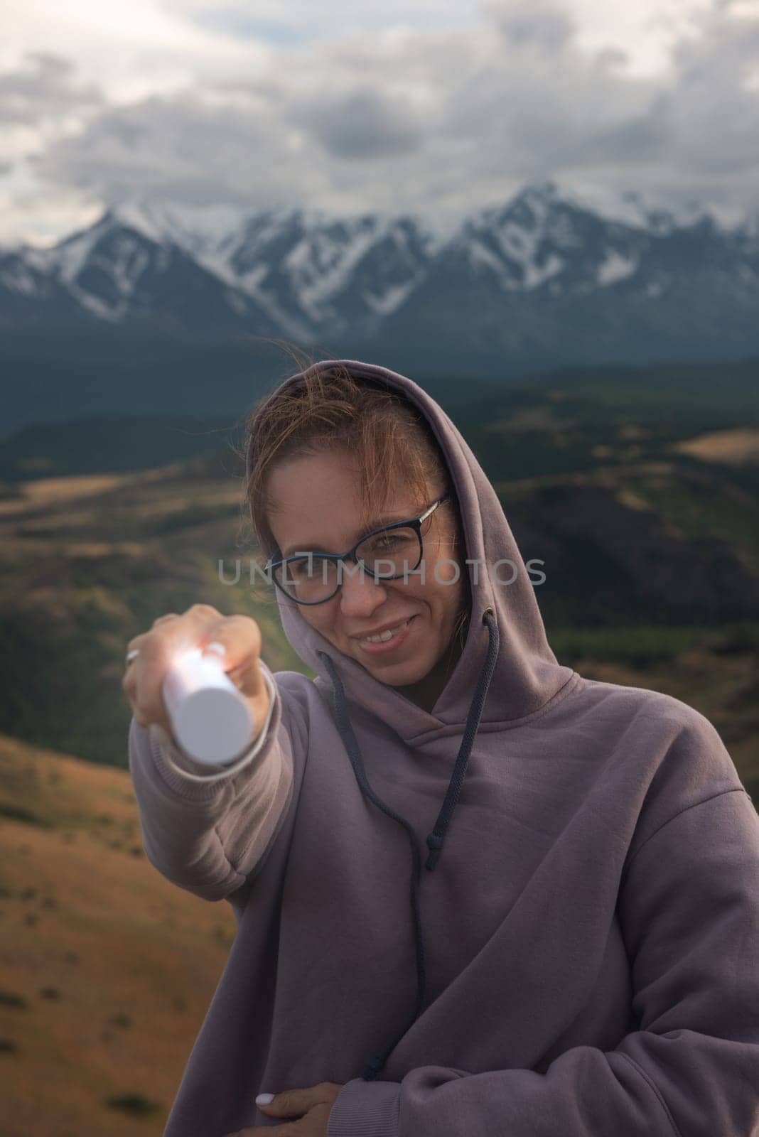 Woman with flashlight in summer Altai mountains in Kurai steppe