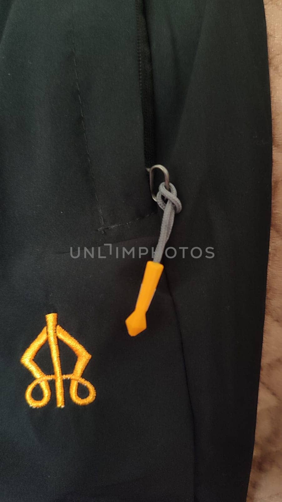 machine embroidery on black trouser fabric, clothing details, pocket and zipper. High quality photo