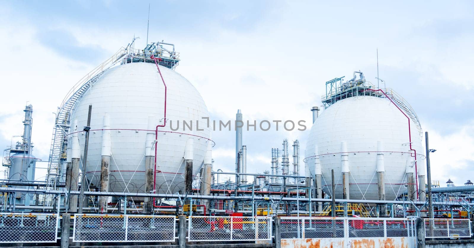 Two petrochemical tanks in the factory with cloudy sky.