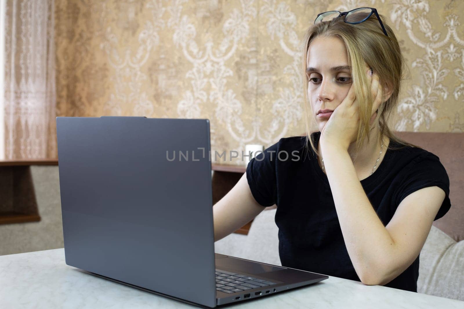 Young woman is deeply and thoughtfully engaged in her work on her laptop, radiating concentration and determination