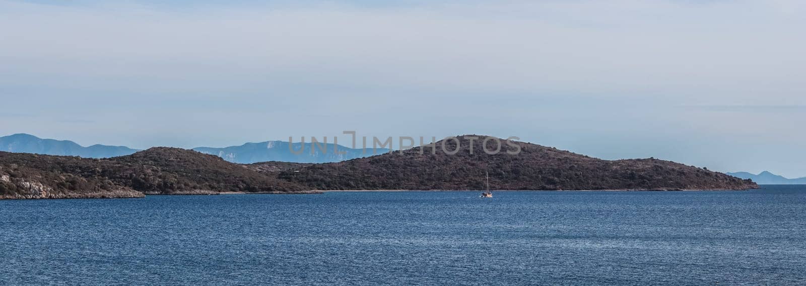 Blue sea, boats and mountains on the coast of the Aegean sea. Summer holidays and coastal nature concept