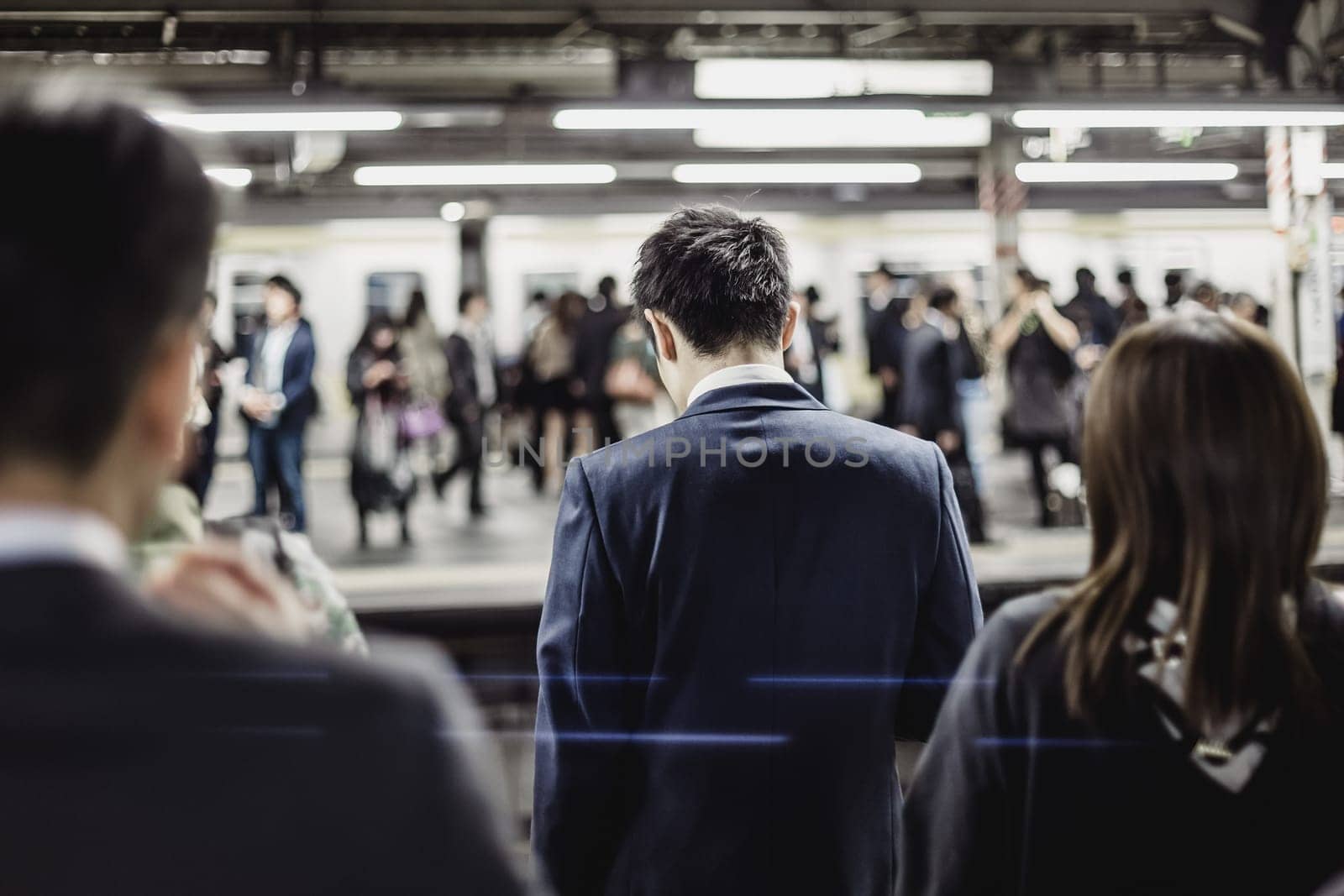 Passengers traveling by Tokyo metro. Business people commuting to work by public transport in rush hour. Shallow depth of field photo.