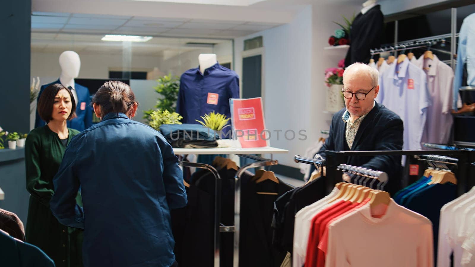 Customers choosing clothes from racks by DCStudio