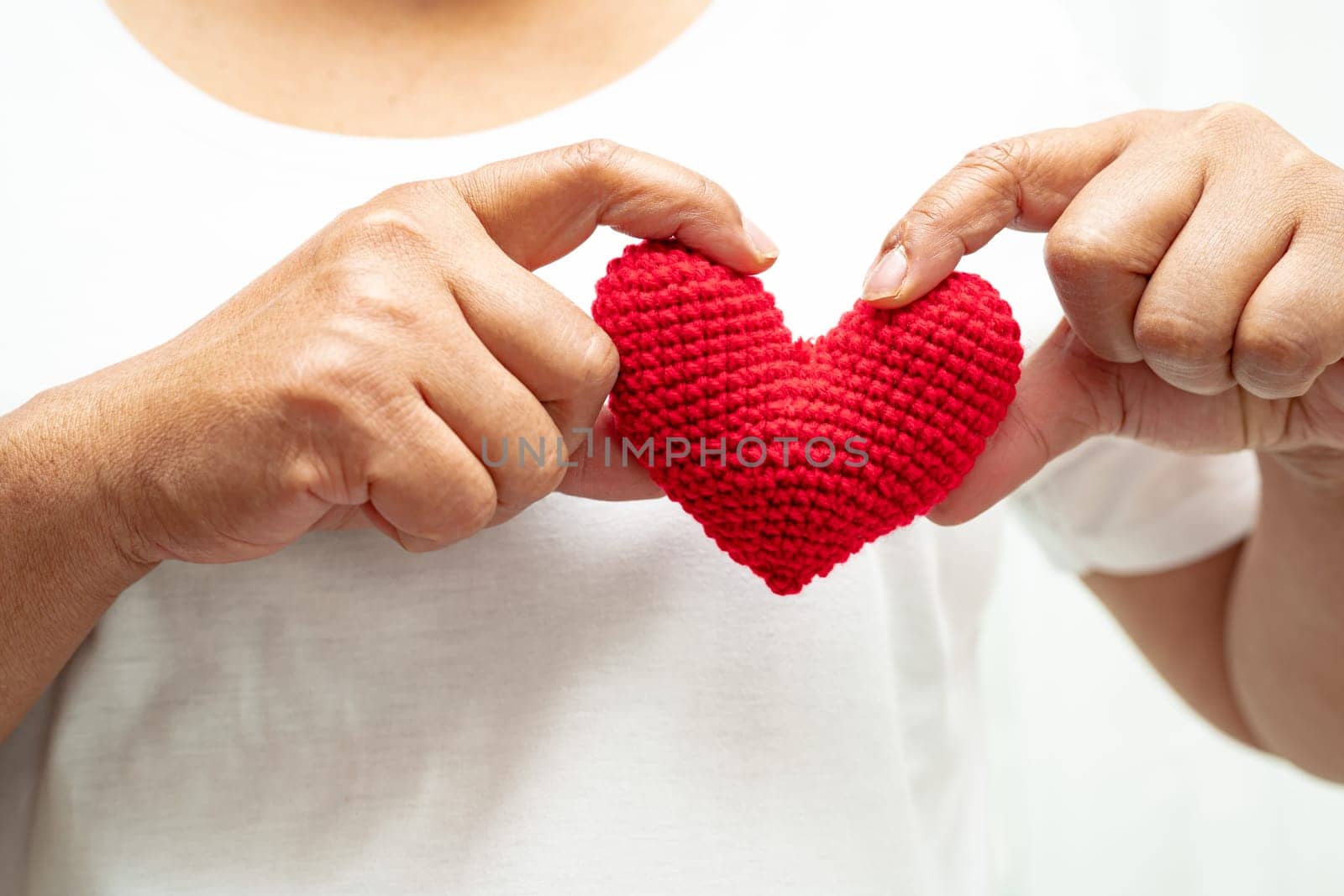 Asian woman volunteer holding a red heart, donation, charity, trust, insurance concept.