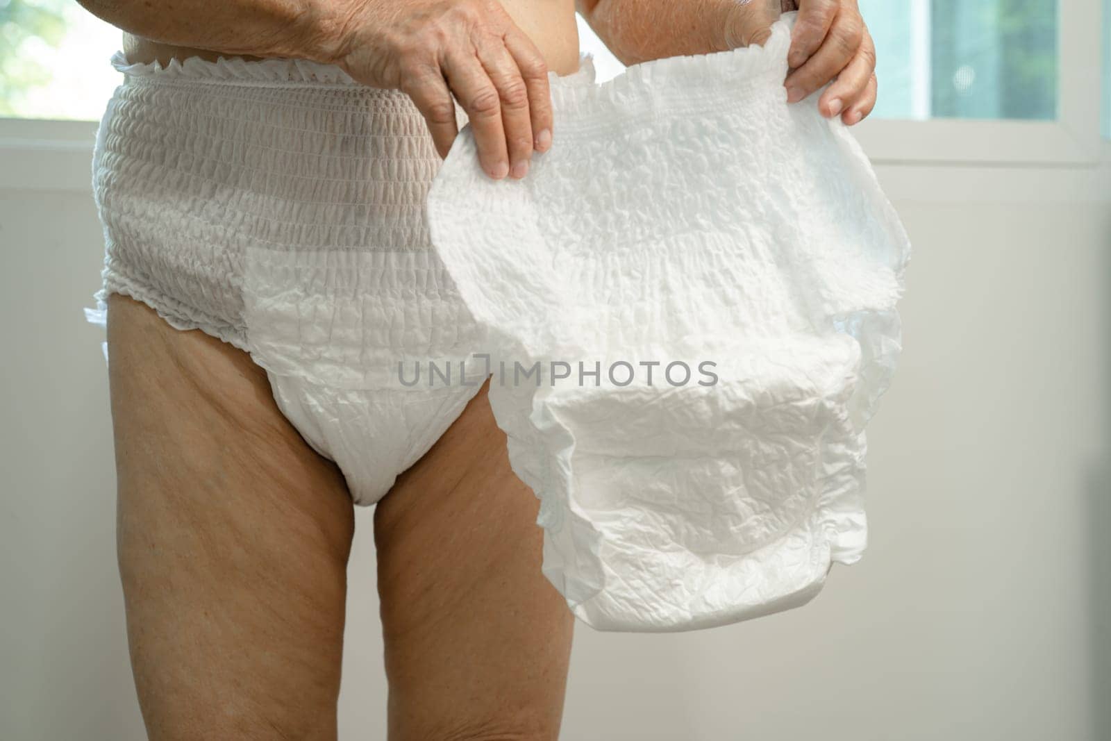 Asian senior woman patient wearing incontinence diaper in hospital, healthy strong medical concept.